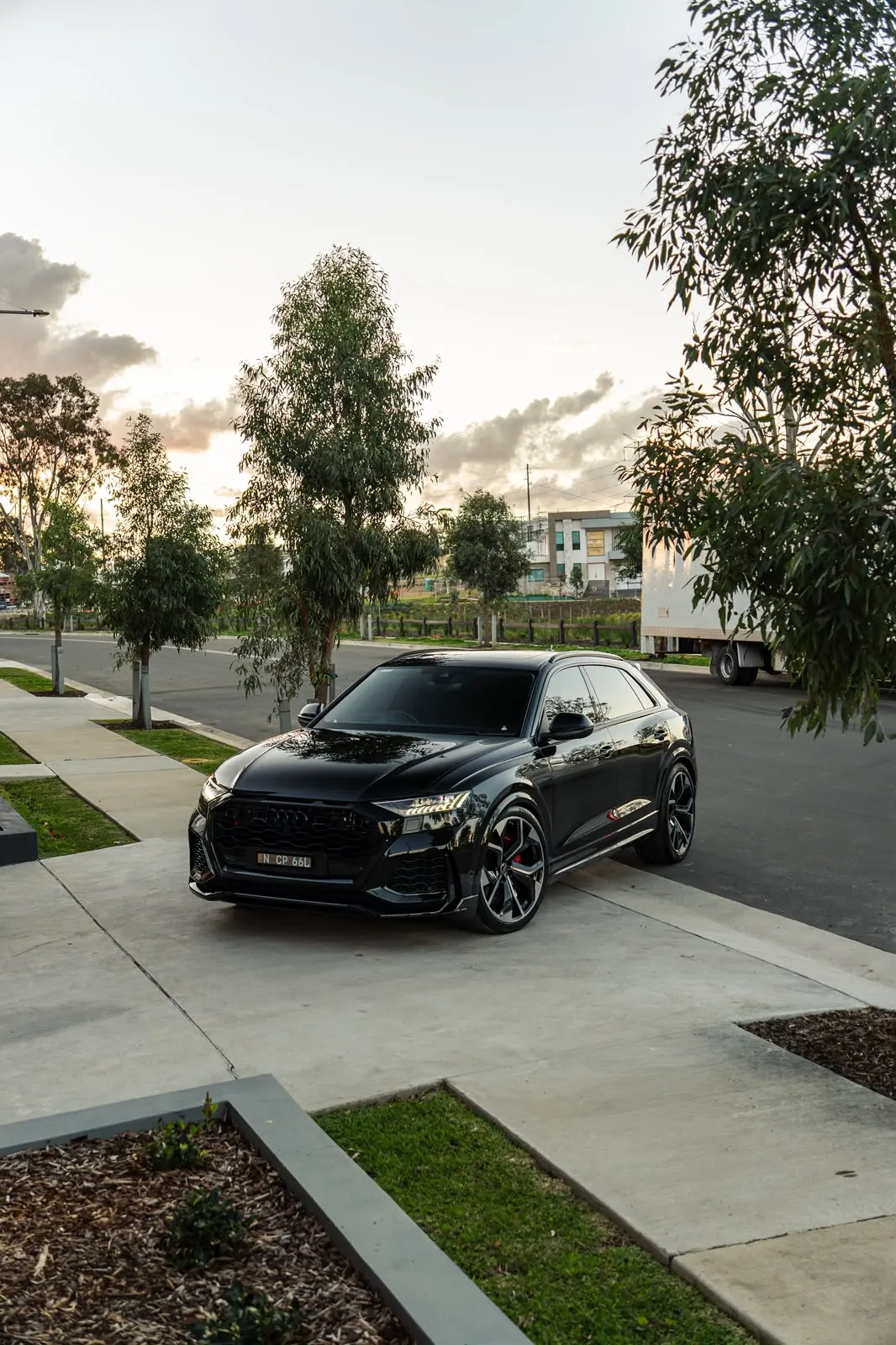 Black Audi Q8 parked on a suburban street at sunset